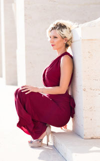 Young woman looking away while sitting outdoors