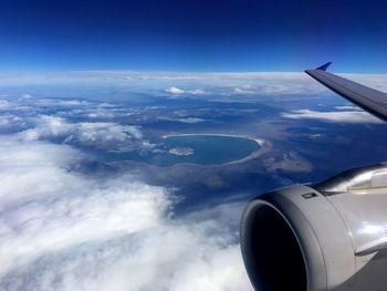 Cropped image of airplane wing over landscape