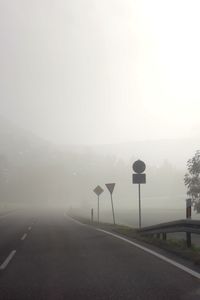 Road by mountains against sky