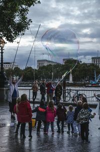 People on riverbank against sky