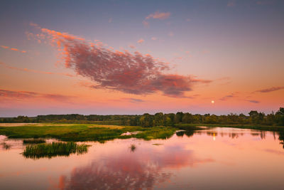 Scenic view of lake against romantic sky at sunset