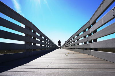 Footbridge against clear blue sky