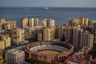 High angle view of buildings by sea against sky