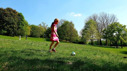 Full length of girl playing soccer at park