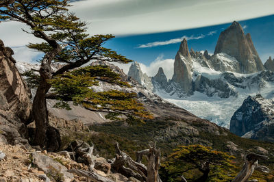 Scenic view of snow covered mountains against cloudy sky