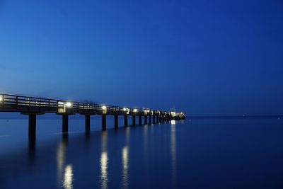 Scenic view of sea against clear blue sky at night