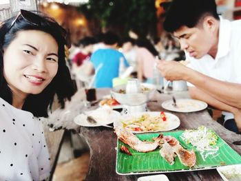 Portrait of a young woman eating food in restaurant