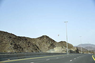 Road by mountain against clear sky