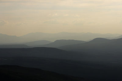 Scenic view of silhouette mountains against sky at sunset