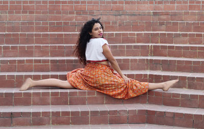 Portrait of woman doing splits on steps