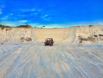 Car on desert against sky