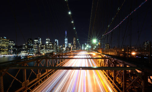 High angle view of light trails on brooklyn bridge over east river at night