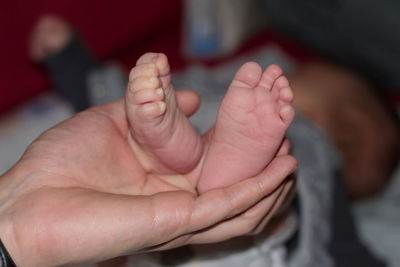 Father holding newborn baby's feet
