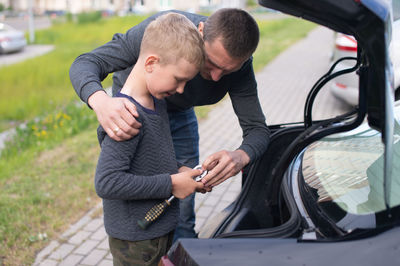 Side view of young woman holding car