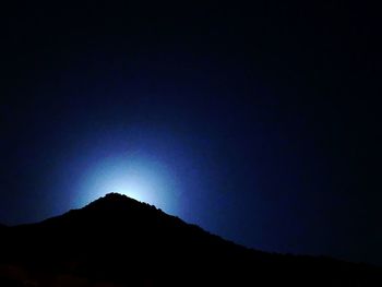 Low angle view of silhouette mountain against sky at night