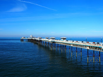 Scenic view of pier in calm sea against blue sky