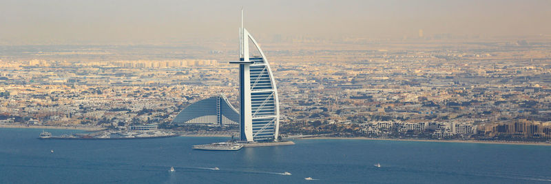 Sailboat on sea against buildings in city