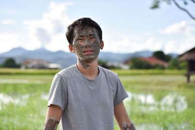Portrait of young man standing on field