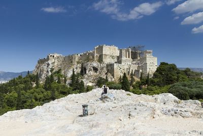 Tourists on rock formation against clear sky