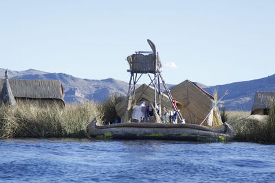 Built structure by water against clear sky