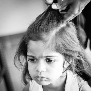 Close-up of adult doing girl's hair