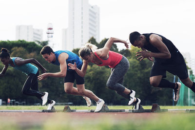 Athletes running from starting blocks on track