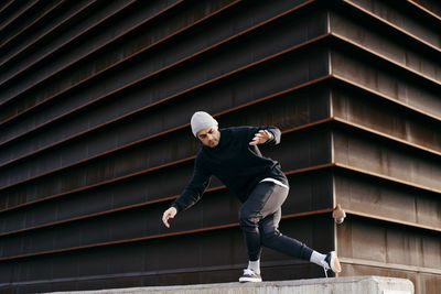 Athletic man doing parkour balance exercises outdoors in urban scene person