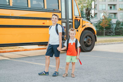 Full length portrait of a smiling boys on road