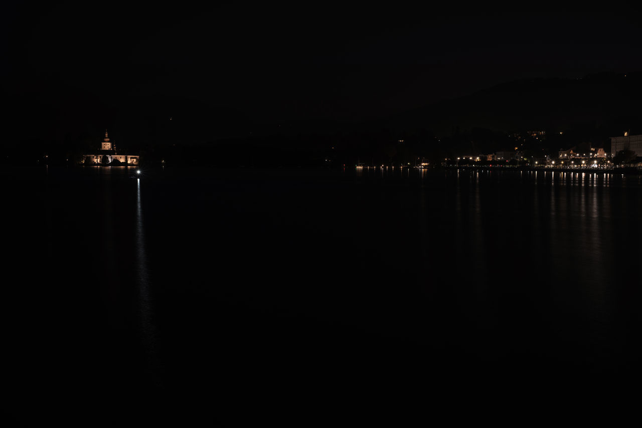 ILLUMINATED BUILDINGS BY SEA AT NIGHT