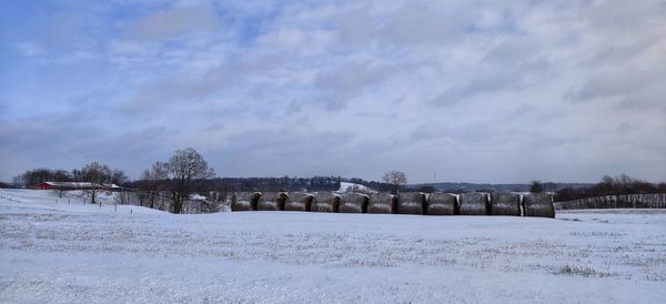 Scenic view of snow covered field against sky