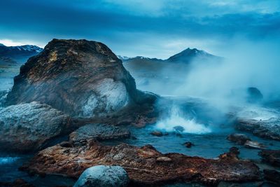 Scenic view of volcanic landscape against cloudy sky
