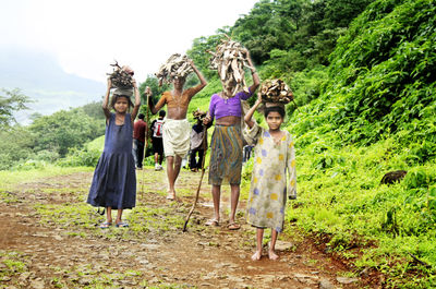 Full length of woman standing on tree trunk