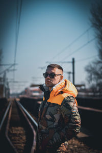 Man standing on railroad track against sky