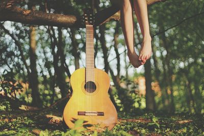 Low section of woman sitting with guitar