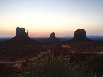 Rock formations on landscape against sky during sunset