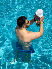 Shirtless man swimming in pool