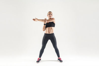 Full length portrait of woman standing against white background