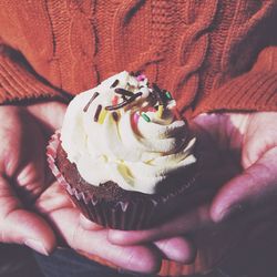 Midsection of person holding cupcake