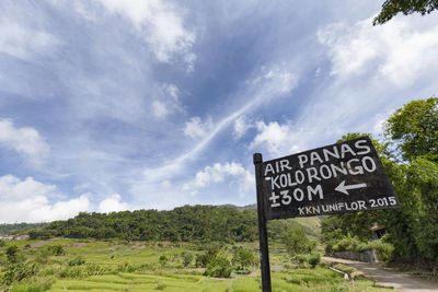 Information sign on landscape against cloudy sky