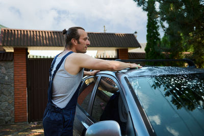 Side view of man sitting in car