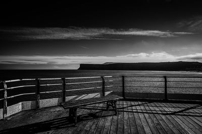 Empty pier over sea against sky