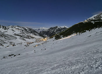 Scenic view of snow covered mountains against blue sky