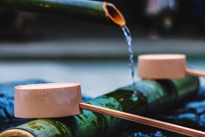 Close-up of wooden ladles on bamboo at drinking fountain