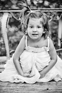 Portrait of girl crouching on walkway