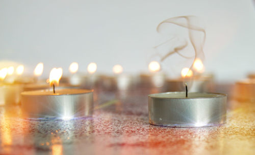 Close-up of lit candles on table in temple
