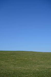 Scenic view of field against clear blue sky