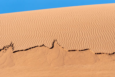 The formation of sands in dasht e lut or sahara desert with waved sand pattern on sand dune. 