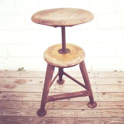 Close-up of empty chair on table against wall