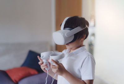 Kid wearing virtual reality goggles. emotional boy playing video games looking in vr headset.