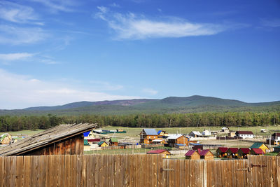 Houses on table by buildings against sky